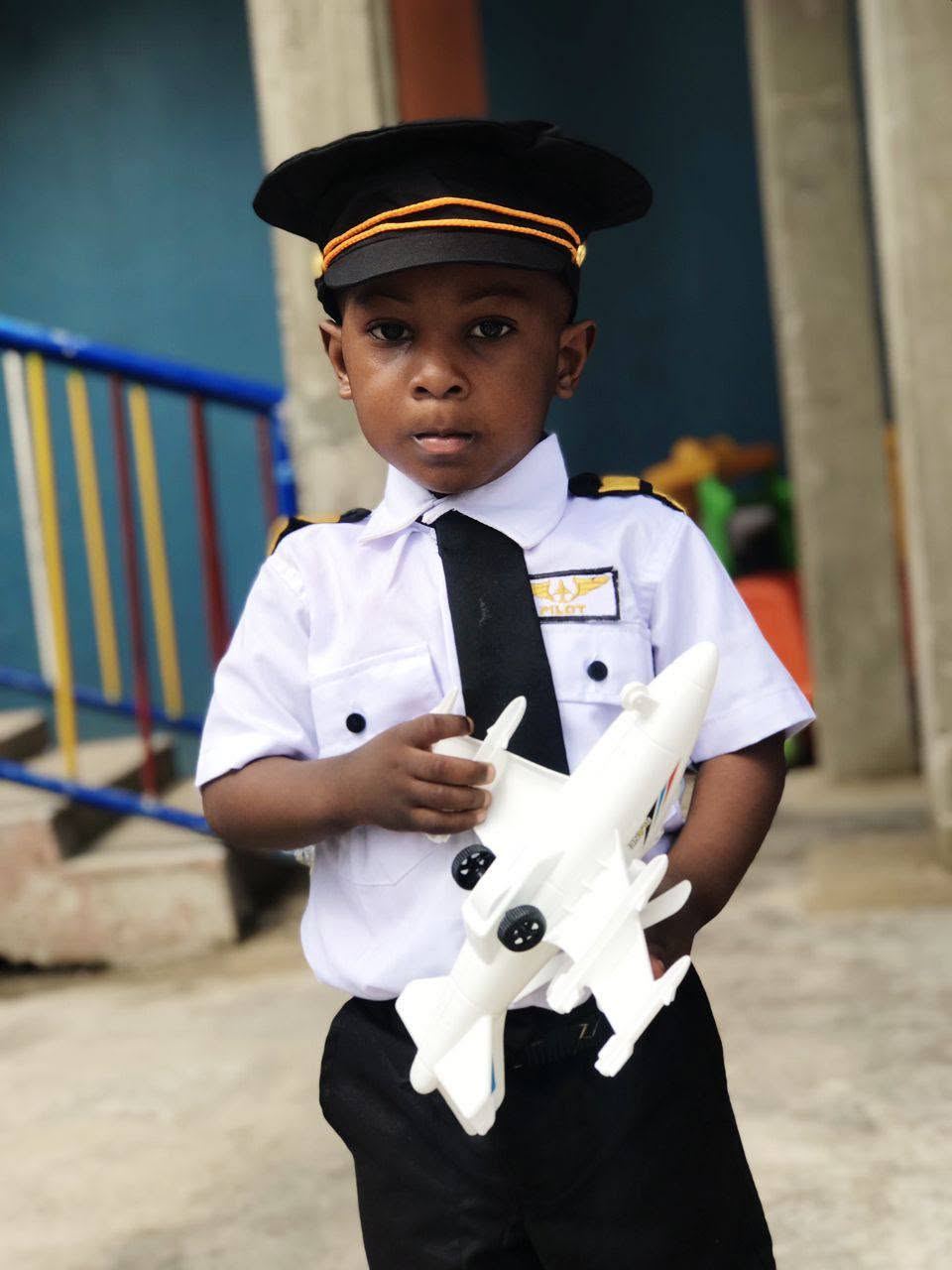 A Regina Mundi pupil dressed as a pilot holding a toy aeroplane