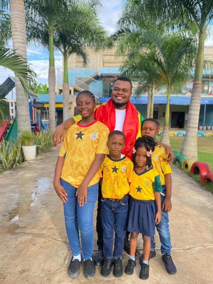 A staff member and Regina Mundi pupils wearing Ghana colours